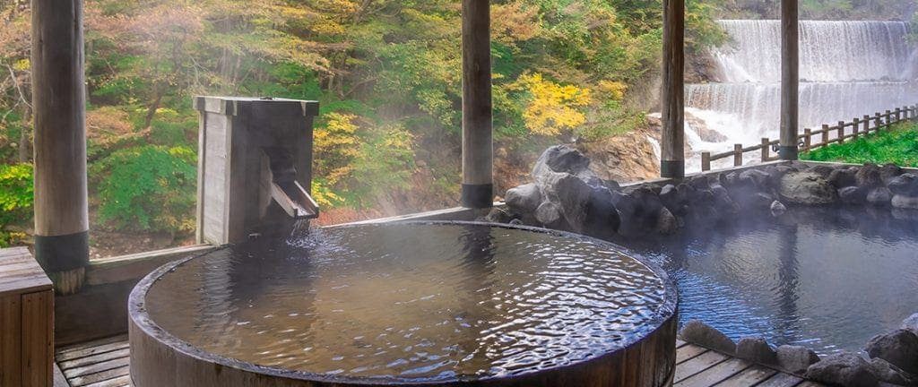 Japanese Hot Springs Onsen Natural Bath Surrounded by red-yellow leaves. In fall leaves fall in Fukushima, Japan