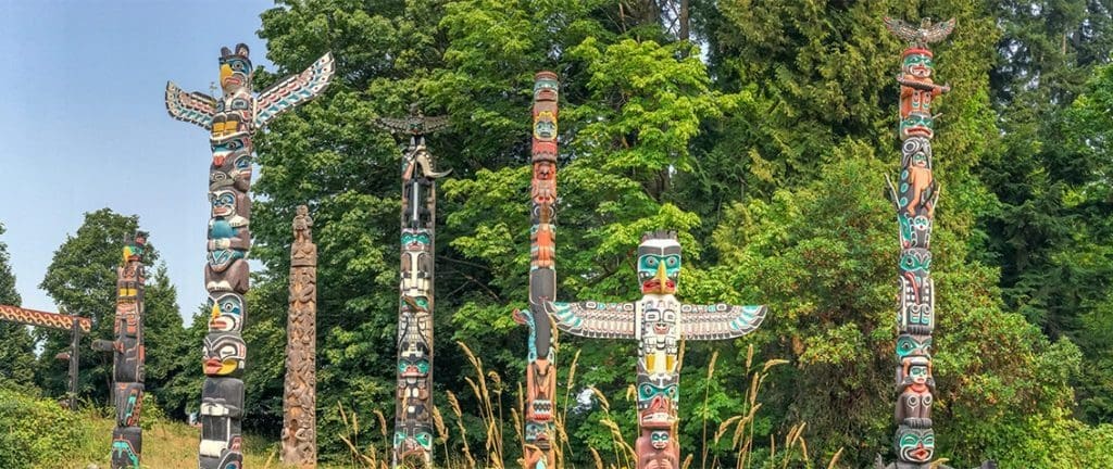 Totem Poles in Stanley Park with colourful paintings.