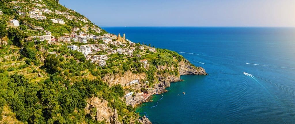 A serene view of Praiano, Italy, nestled on the Amalfi Coast, showcasing its picturesque cliffs, charming buildings, and panoramic vistas of the Mediterranean Sea.