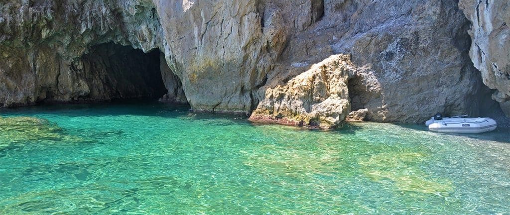 A mesmerizing image of the Emerald Cave, featuring its enchanting emerald-hued waters illuminated by natural light, creating a captivating and magical ambiance.  Perfect travel destination along the Amalfi Coast.