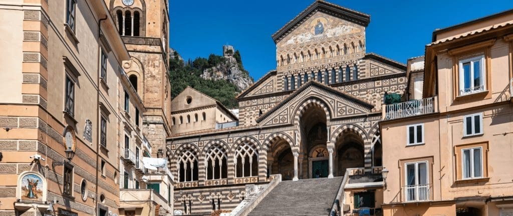 The majestic Duomo di Amalfi, an iconic cathedral standing tall in Amalfi, adorned with intricate architecture and a striking bell tower, showcasing centuries of history and religious significance.