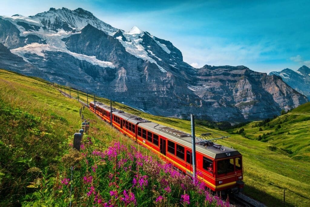 Electric passenger train and snowy Jungfrau mountains in background